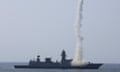 Smoke rises from an Indian navy ship as it fires a projectile into the air