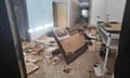 A wrecked office with smashed furniture and debris strewn on the ground