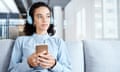 Female on couch listening to podcast, radio or sound with mobile smartphone.