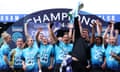 London City Lionesses manager Jocelyn Prêcheur hoists the Women’s Championship trophy high alongside his celebrating players