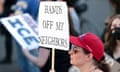 A person holds a sign that reads "hands off my neighbors" during the "Tacoma May Day - Stand Up for Worker and Immigrant Rights!" march and rally outside the Northwest ICE Processing Center in Tacoma, Washington on May 1, 2025. (Photo by Jason Redmond / AFP) (Photo by JASON REDMOND/AFP via Getty Images)
