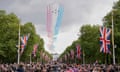 The Red Arrows in formation streaming red, white and blue over a packed crowd in the Mall decked out with union flags