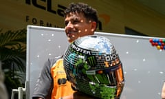 Lando Norris holds his team helmet
