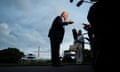 Trump talks to silhouetted reporters with helicopter and Washington Monument in the background