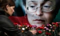 A woman places flowers in front of a portrait of Russian journalist Anna Politkovskaya, Moscow,  2009.