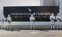 People dressed as Storm Troopers in front of a Pinewood Studios sign