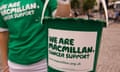 A volunteers holds a donations bucket with the message: 'We are Macmillan Cancer Support'