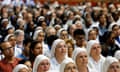 People, mostly nuns, sitting in rows facing in the same direction