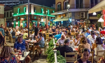A busy set of tables outside a Greek taverna