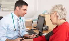 A British doctor checks an older woman's blood pressure.