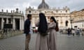 Two nuns and a man speak outside St. Peter's Basilica in Rome