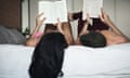 Young couple lying in bed reading books
