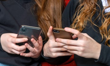 teenage school girls on their phones